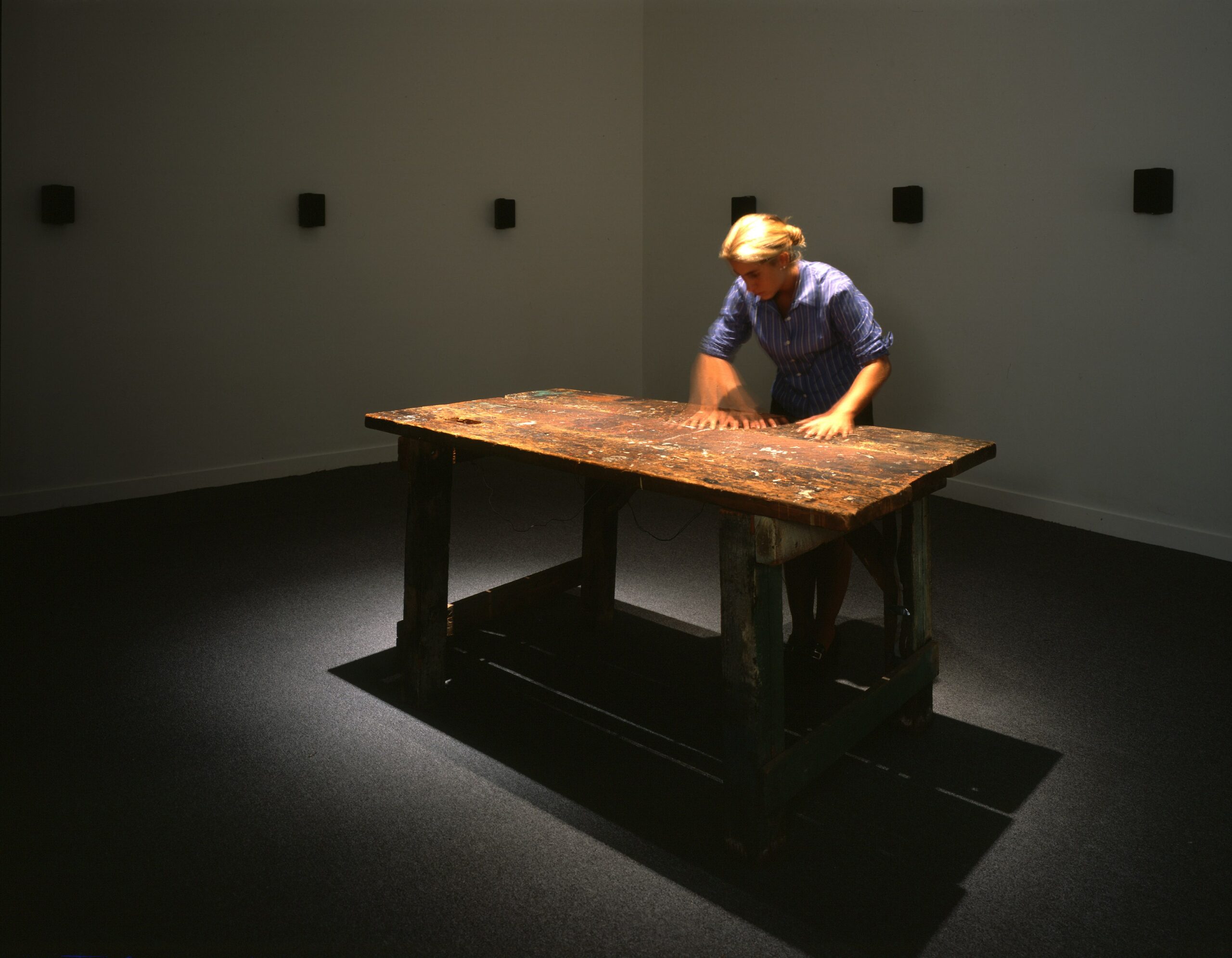 Janet CardiffTo Touch, 1993 Wooden carpenter's table, electronic photo cells, 16 audio speakers Dimensions: Table: 98cm x 140cm, room size variable © Janet Cardiff; Courtesy of the artist and Luhring Augustine, New York. 